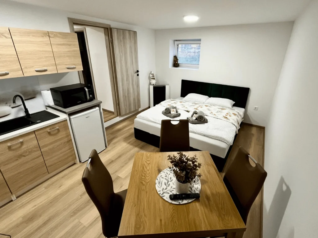 Osrednji prostor z posteljo, jedilnim prostorom in kuhinjo v apartmaju Center Ljutomer za 4 osebe